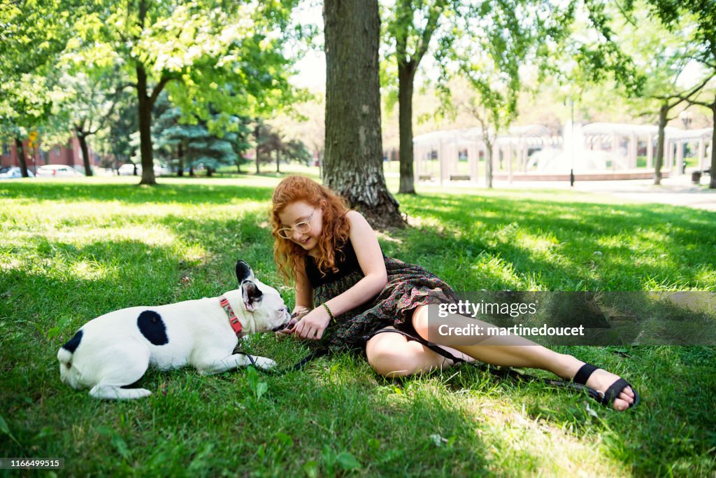 Tiener Redhead meisje in een park met een hond