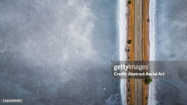 drone shot of a road on a salt flat, western australia - western australia road stock pictures, royalty-free photos & images