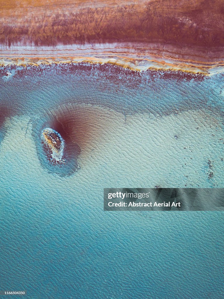 Aerial perspective at the edge of a vibrant coloured salt pool, Western Australia