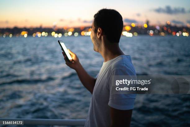 side view of a man making a video chat at a boat - boat side view stock pictures, royalty-free photos & images