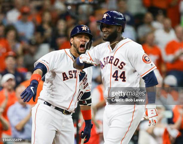 Yordan Alvarez of the Houston Astros celebrates with Yuli Gurriel after hitting a home run in the second inning against the Colorado Rockies at...
