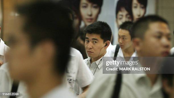 Chinese businessmen leave a crowded subway station on their way to work in the Pudong financial district of Shanghai, 02 August 2006. Venu du sud de...