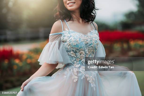 une robe asiatique de modèle féminin chinois vers le haut avec la robe de mariage pour la session extérieure de portrait au parc public le soir - evening gown photos et images de collection