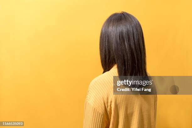 woman in yellow facing yellow background - black hair isolated stock pictures, royalty-free photos & images