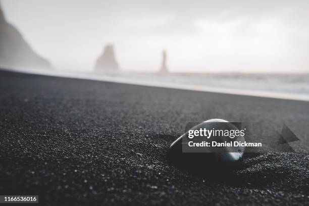 pebble on a black sand beach at reynisfjara, iceland - black sand stock pictures, royalty-free photos & images