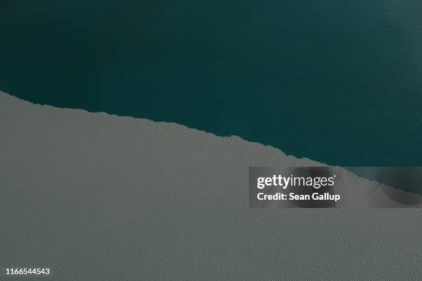 In this view from an airplane silty meltwater coming from the Greenland ice sheet meets clean water in a lake near the Sermeq Avangnardleq glacier on...