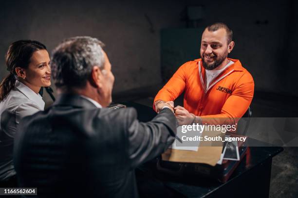 man gevangene schudden hand met advocaat in ondervrachting kamer - probatie stockfoto's en -beelden