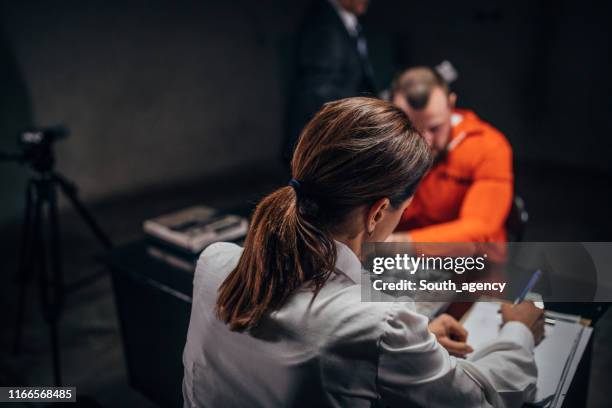 woman detective interrogating a man prisoner in interrogation room - probation stock pictures, royalty-free photos & images