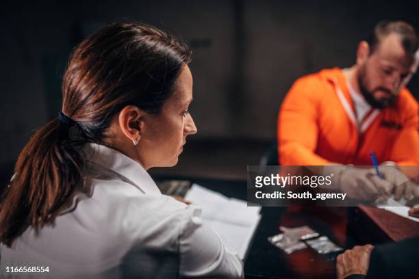 lady detective interrogating a man prisoner in interrogation room - confession law stock pictures, royalty-free photos & images
