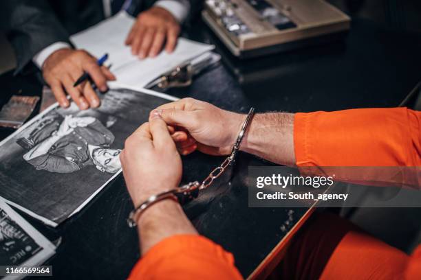 man with handcuffs shaking in interrogation room - confession law stock pictures, royalty-free photos & images