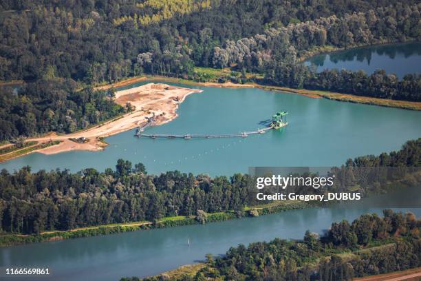 kleine franse steengroeve industrie met zand-en grind-stack luchtfoto midden in de natuur langs de rivier de rhône in het departement ain, regio auvergne-rhône-alpes - mini digger stockfoto's en -beelden
