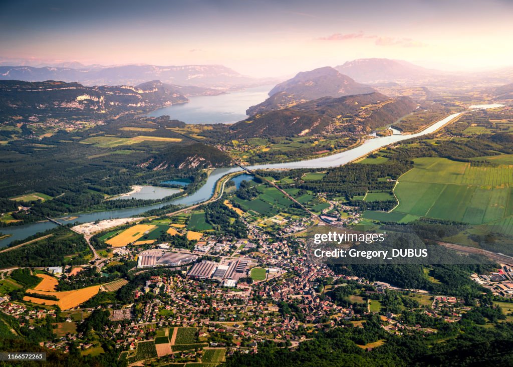 Aerial view of beautiful French landscape at sunset in Bugey mountains, in Ain department Auvergne-Rhone-Alpes region, with Culoz small town, the Rhone River and famous Lake Bourget in background in summer