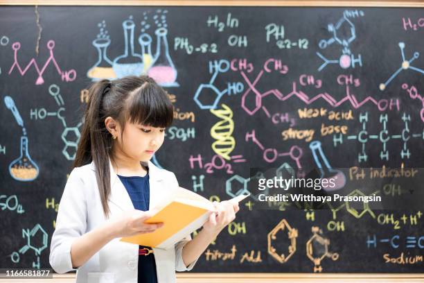 a small girl reading a school book - small smart girl stock pictures, royalty-free photos & images