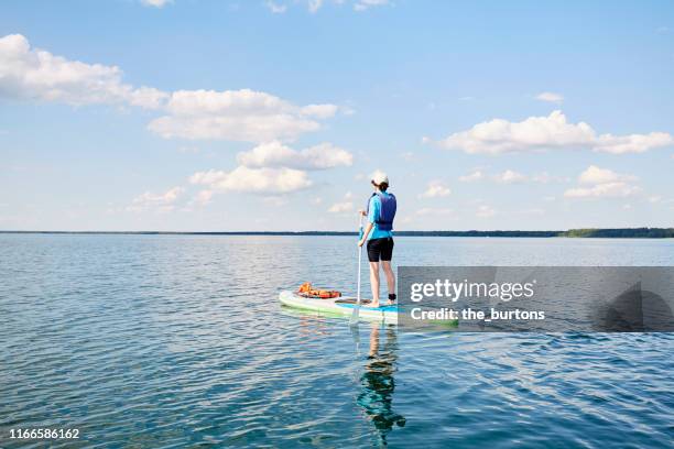 woman paddle boarding (sup) on lake müritz, mecklenburg-vorpommern, germany - using a paddle stock pictures, royalty-free photos & images