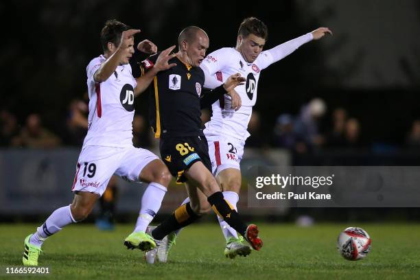 Neil Kilkenny of the Glory passes the ball against Pirmin Schwegler and Nicholas Sullivan of the Wanderers during the FFA Cup Round of 32 match...