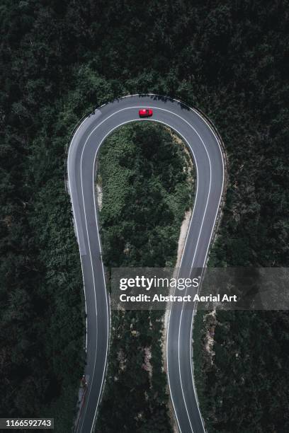 Drone image of a hairpin bend in a forest, Italy