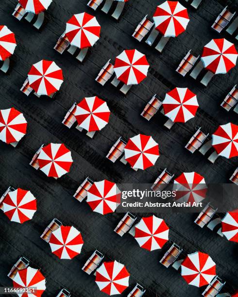 Drone image directly above beach umbrellas, Massa, Italy