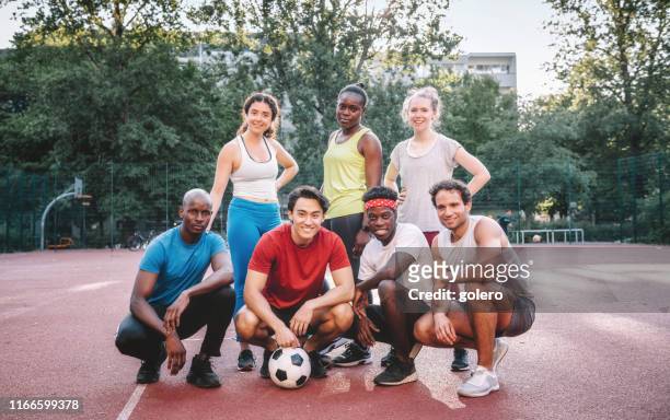 mannschaftsfoto von mixed-fußballmannschaft auf hartplatz - international team soccer stock-fotos und bilder