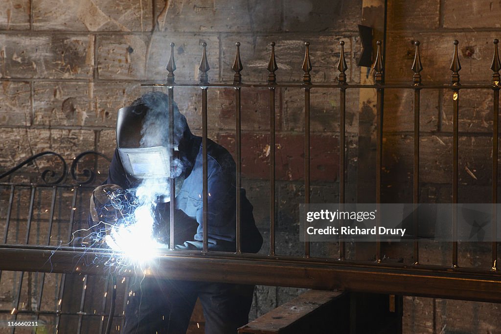 Apprentice welder making fence