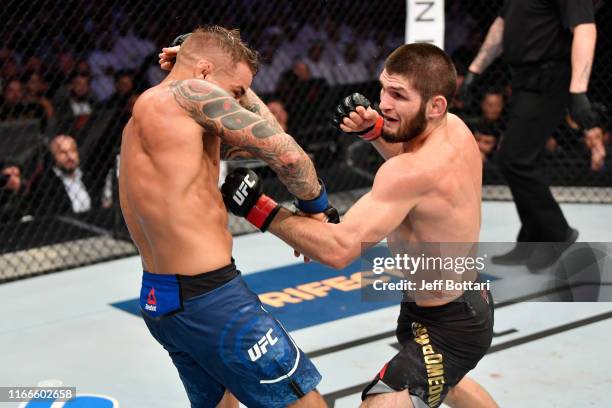 Khabib Nurmagomedov of Russia punches Dustin Poirier in their lightweight championship bout during UFC 242 at The Arena on September 7, 2019 in Yas...