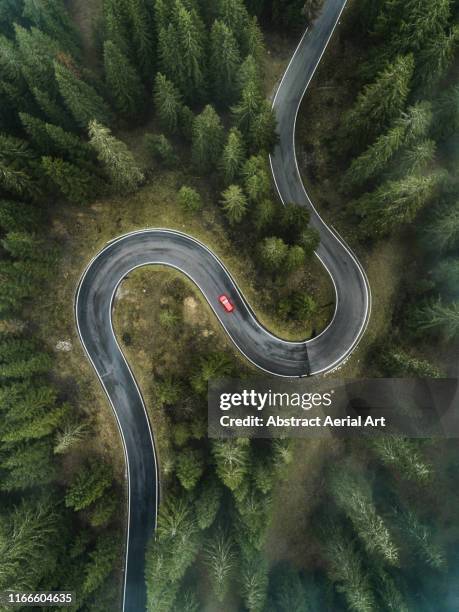 a car driving on a winding forest road seen from directly above, dolomites, italy - car country road photos et images de collection