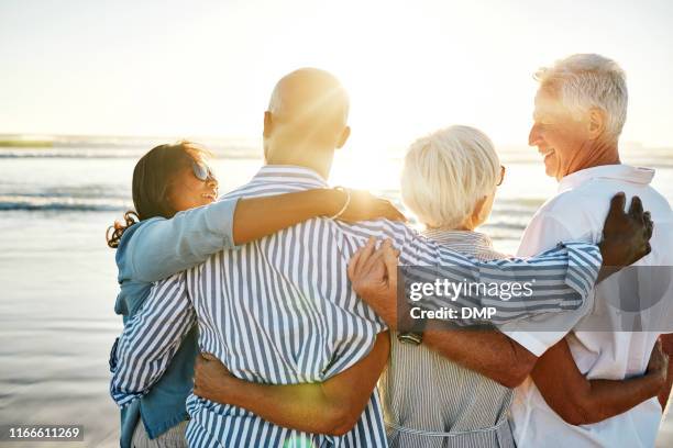 true friends stick together through the years - older couple hugging on beach stock pictures, royalty-free photos & images