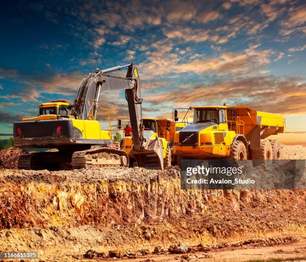 excavadora y camiones de volteo en la obra - construction equipment fotografías e imágenes de stock