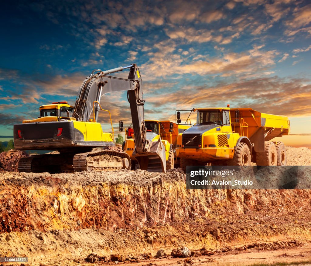 Graafmachines en dump trucks op de bouwplaats