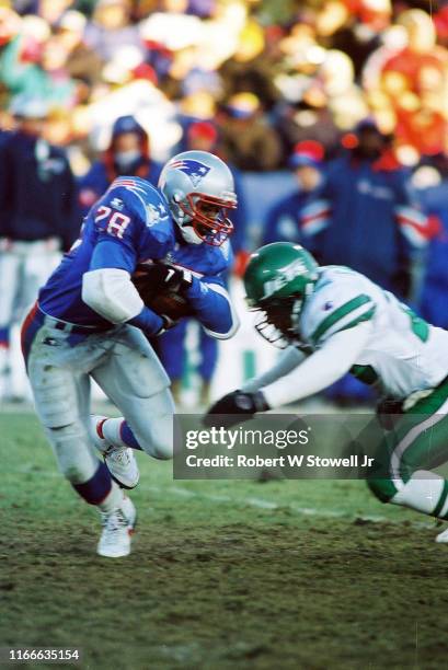 American football player Curtis Martin , of the New England Patriots, tries to evade a tackle during a game against the New York Jets, Foxboro,...