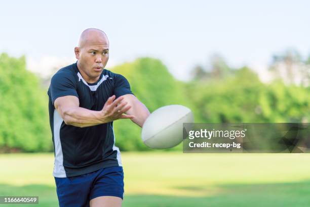 rugby speler passerende bal naar teamgenoot - rugby league stockfoto's en -beelden