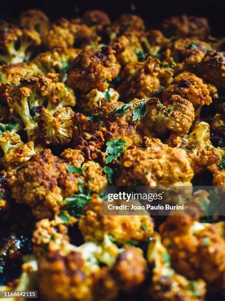 vegan dish, baked cauliflower on a dark tray - comida vegetariana stock pictures, royalty-free photos & images