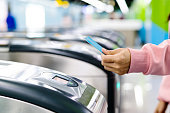 Woman hand scanning train ticket to subway entrance gate. Transportation concept