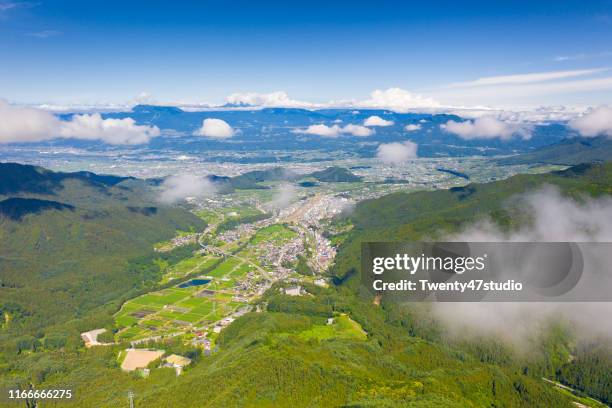 aerial view of yamanouchi town from mount shigakogen by drone against japan northern alps in background - nagano prefecture stock-fotos und bilder