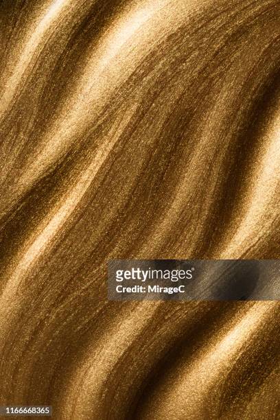 flowing shiny gold paint wave pattern - shiny fabric stock pictures, royalty-free photos & images