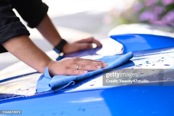 cropped hand of man cleaning car hood,car washing concept - towel ストックフォトと画像