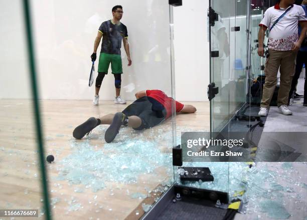 Alvaro Beltran of Mexico lies on the court after he collided and smashed the glass wall during his match against Rodrigo Montoya of Mexico in the...