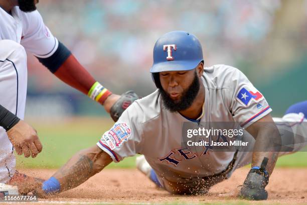 Danny Santana of the Texas Rangers dives back to first base on a pick-off attempt during the third inning against the Cleveland Indians during game...