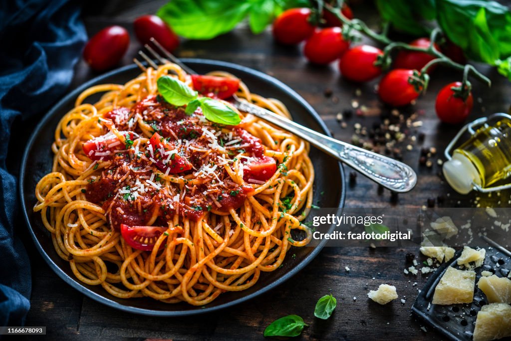 Espaguete com o molho de tomate disparado na tabela de madeira rústica