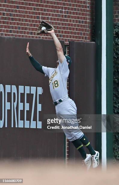 Chad Pinder of the Oakland Athletics makes a leaping catch at the left field wall against the Chicago Cubs at Wrigley Field on August 07, 2019 in...