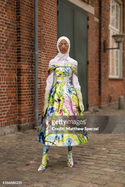 Guest is seen on the street attending Copenhagen Fashion Week SS20 wearing white hijab, colorful design dress and shoes on August 07, 2019 in...