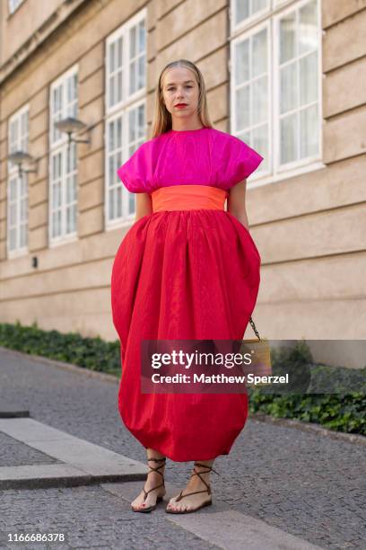 Guest is seen on the street attending Copenhagen Fashion Week SS20 wearing pink/red dress with orange belt and bag on August 07, 2019 in Copenhagen,...