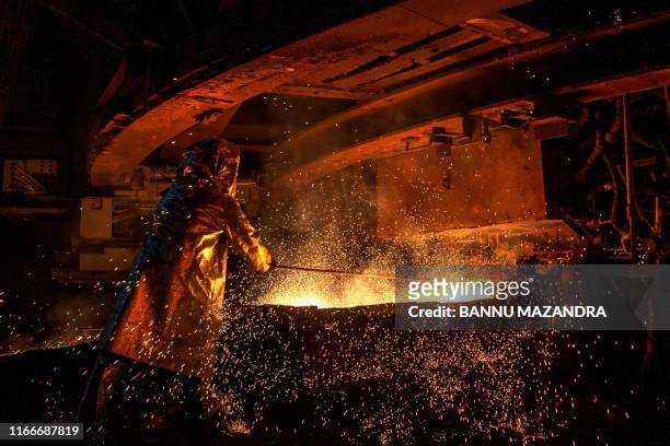 This picture taken on March 30, 2019 shows a worker manning a furnace during the nickel smelting process at Indonesian mining company PT Vale's...