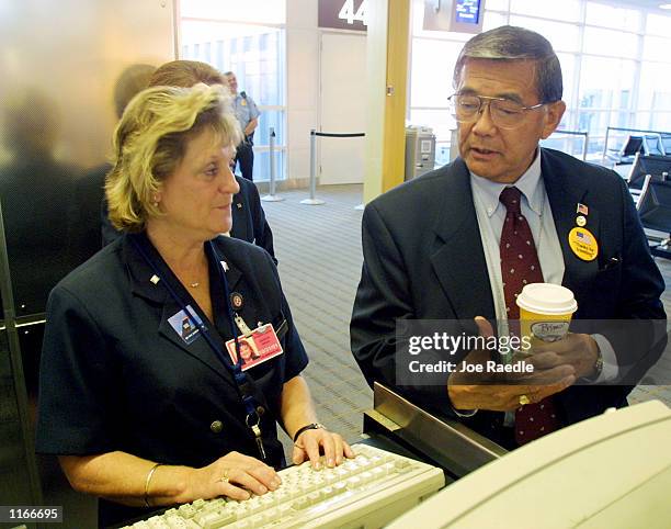 Norman Mineta , the U.S. Transportation Secretary, speaks with an airline employee October 4, 2001 at the Ronald Reagan Washington National Airport...