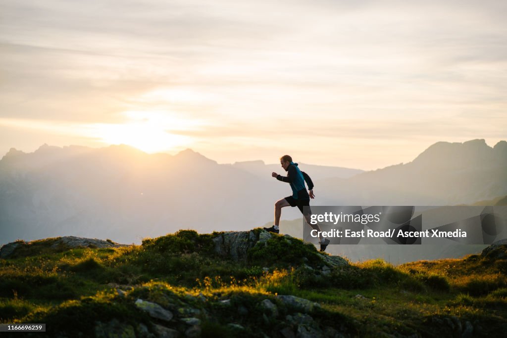 Trail runner traverses mountain ridge crest