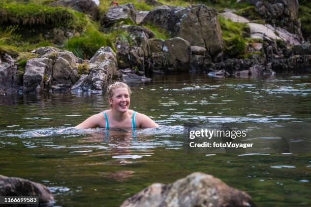 femme sauvage de natation dans le ruisseau clair de ruisseau de lac cumbria - weed photos et images de collection