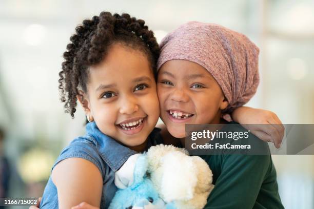 little girl with cancer hugs her best friend - cancer cell stock pictures, royalty-free photos & images