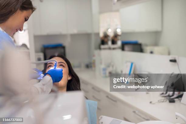 dentist and performing dental drilling - focus on foreground stock pictures, royalty-free photos & images