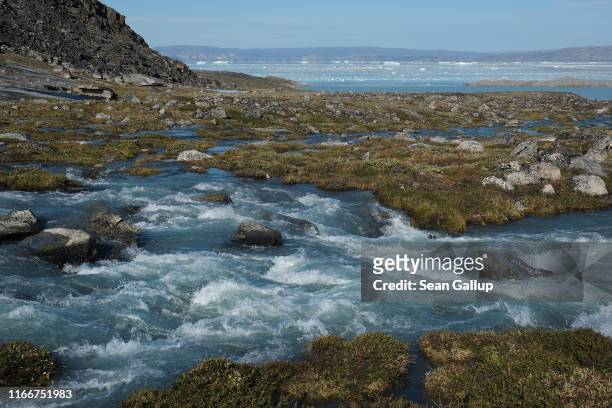 Water from the Greenland ice sheet causes a creek to overflow into a whitewater stream during unseasonably warm weather on August 01, 2019 at Eqip...
