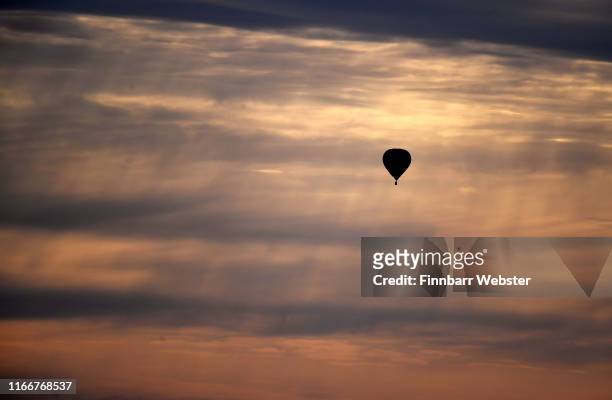 Hot air balloons take to the skies as they participate in the mass ascent at sunrise on the first day of the Bristol International Balloon Fiesta on...