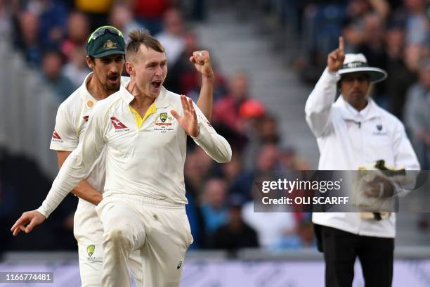 Umpire Kumar Dharmasena indicates 'out' as Australia's Marnus Labuschagne celebrates after taking the wicket of England's Jack Leach during play on...